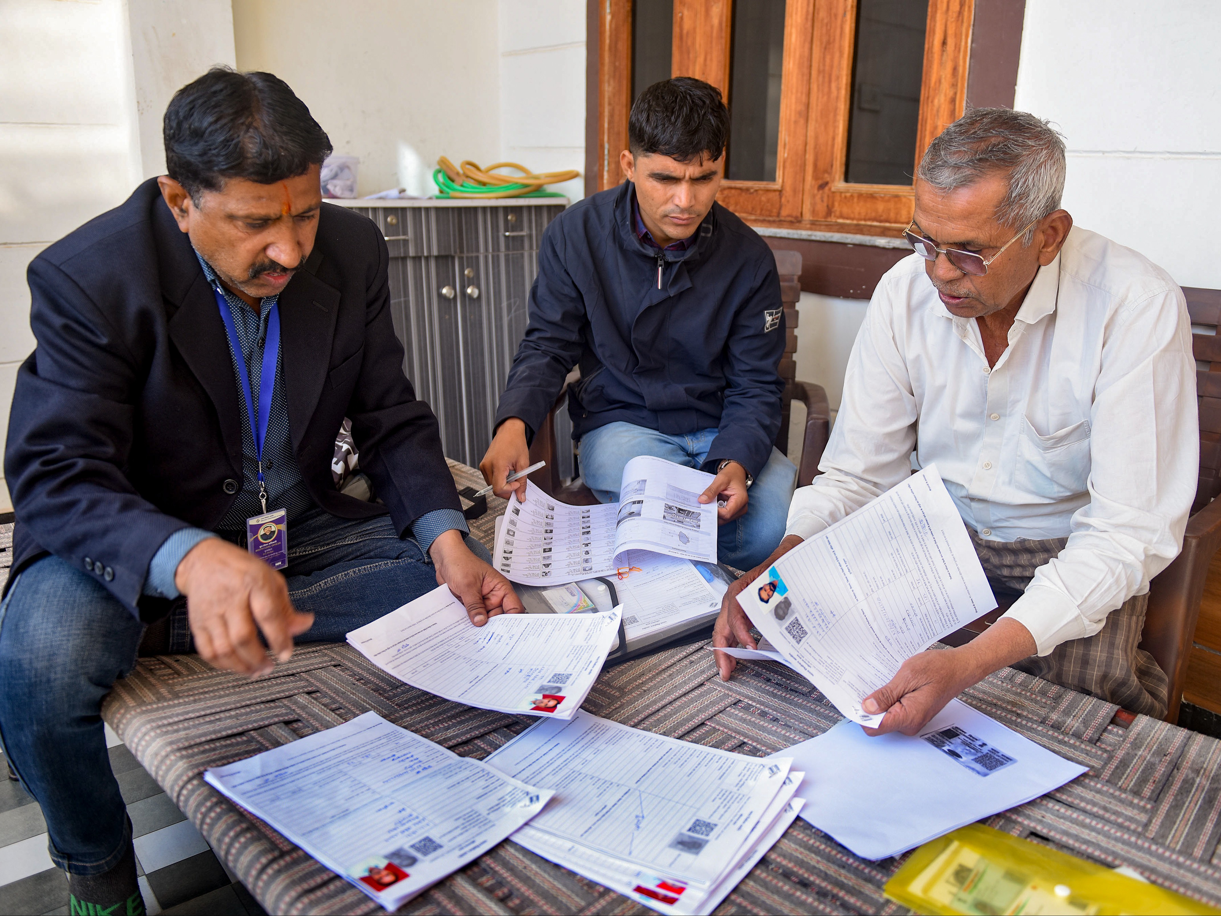 राजस्थान के बीकानेर में मंगलवार को बूथ लेवल ऑफिसर SIR के लिए फॉर्म भरने में वोटर की मदद करते दिखे। - Dainik Bhaskar