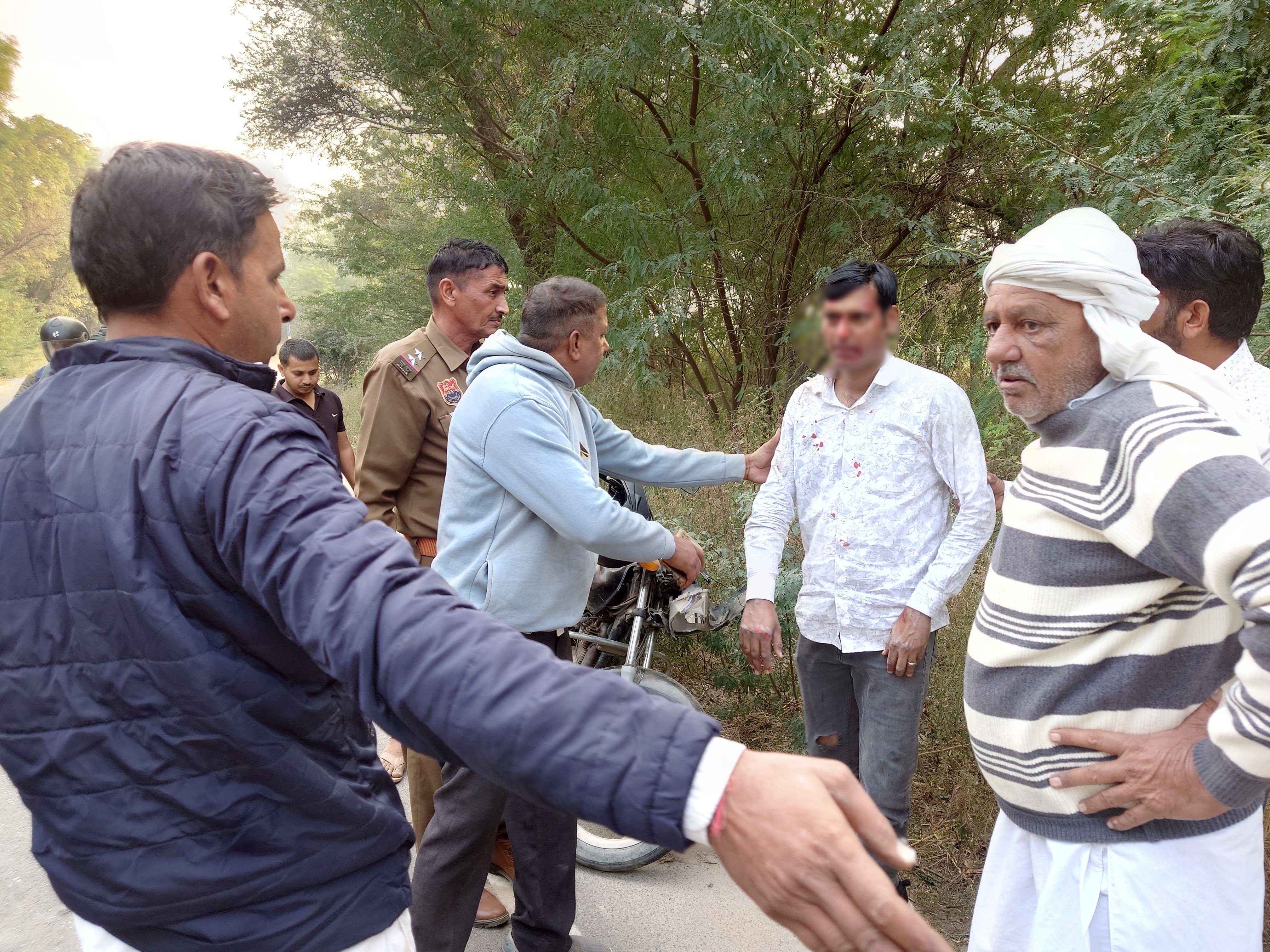 घायल को संभालते राहगीर और पुलिस।