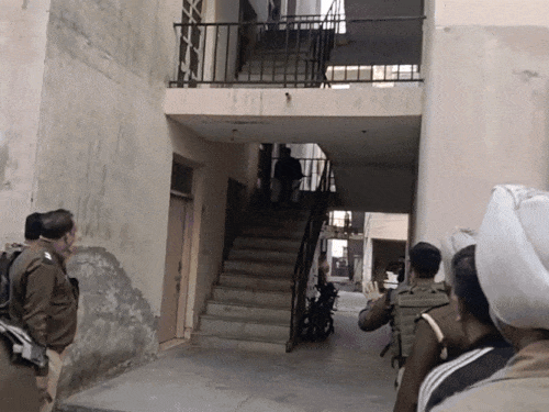 पुलिस स्टेशन की सीढ़ियों पर बैठा आरोपी पुलिसकर्मी हाथ में AK-47 लिए पुलिस से बातचीत करता हुआ दिखाई दिया। - Dainik Bhaskar