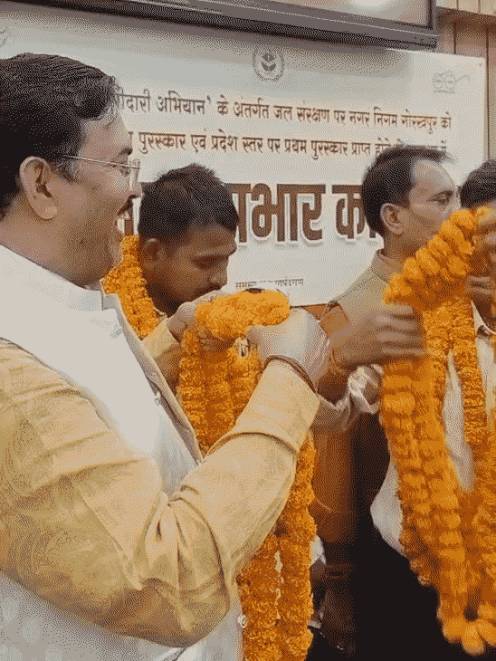 मंच पर पार्षदों से मिलते मेयर और नगर आयुक्त