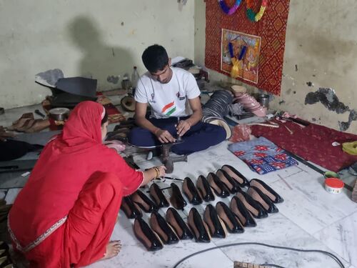 चप्पल बनाने की दुकान पर काम करते नीरज।