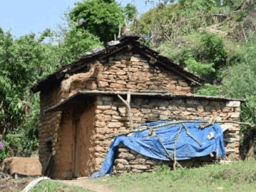 A house of Vanraji family and a person standing in front of the house.