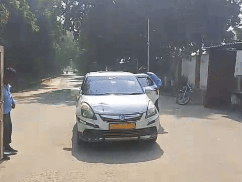 यूनिवसिर्टी कैंपस से बाहर जाती गाड़ी को चेक करते गार्ड।