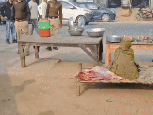 गांव धौज में बाजार मे लोगों से उनके कागजात चेक करते हुए पुलिस।