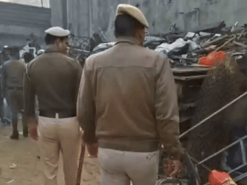 बाजार में कबाड़ के गोदाम को चेक करते हुए पुलिस के कर्मचारी।