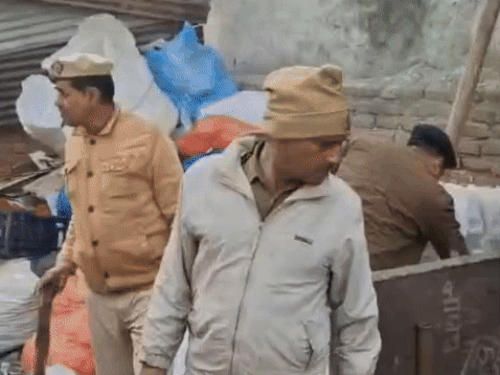 कबाड़ गोदाम में पड़े कबाड़ के सामान को चेक करते हुए पुलिस।