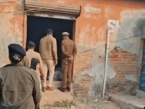 गोदाम को चेक करते हुए पुलिस कर्मचारी।