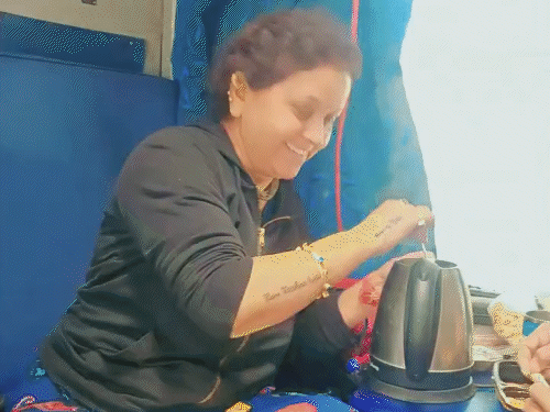 महिला केतली में नूडल्स बनाने की तैयारी कर रही है।