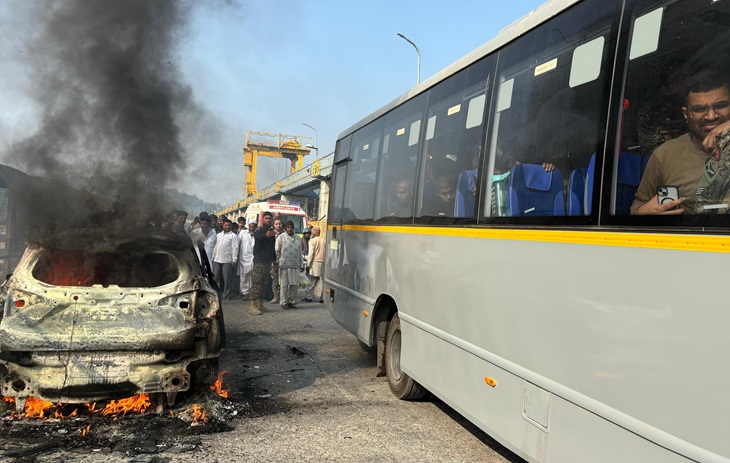 जल रही गाड़ी के पास से गुजरती आर्मी की बस, जो काफी देर जाम में फंसी रही।