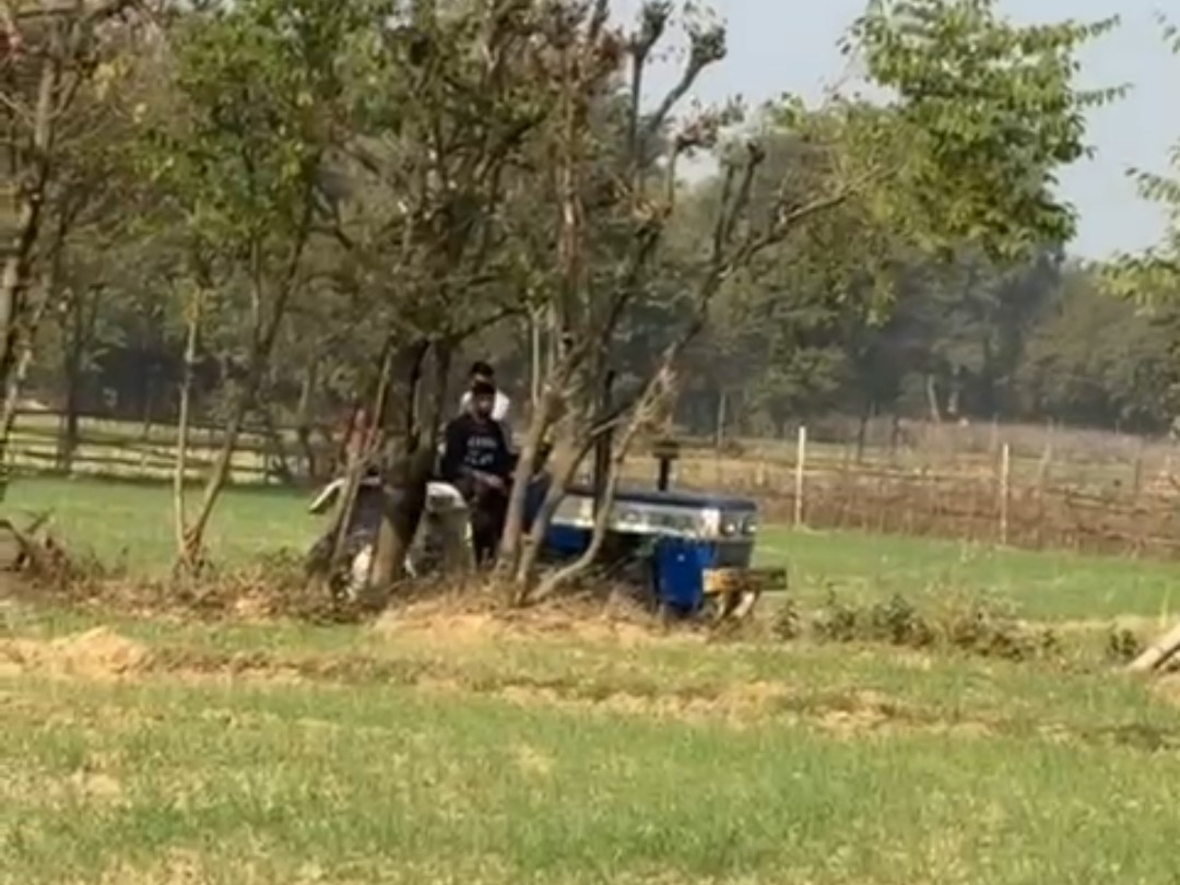 ट्रैक्टर की मदद से युवक को नीचे उतारते ग्रामीण।