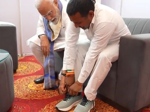 रामपाल कश्यप जब जूते पहन रहे थे तो मोदी ने नीचे झुककर उनके फीते बांधने में मदद की। (फाइल फोटो)