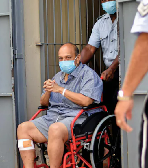 व्हीलचेयर पर बैठा मेहुल चोकसी। तस्वीर 4 जून 2021 को डोमिनिका के एक मजिस्ट्रेट कोर्ट की है।