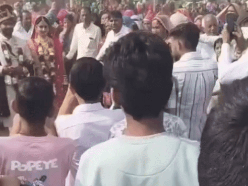 हेलिपेड पर खड़े दुल्हा-दुल्हन और परिवार के लोगों के साथ ग्रामीण।