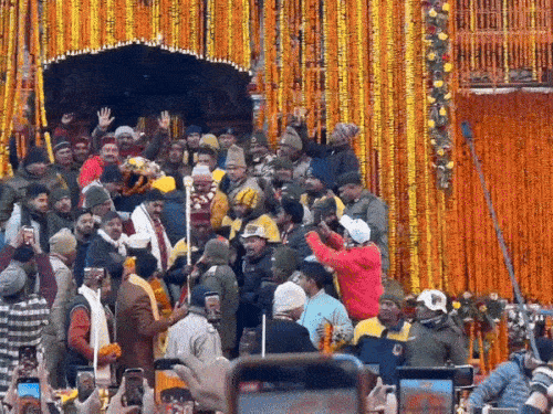 उद्धव और कुबेर की प्रतिमाओं को मंदिर से बाहर लाते पुजारी।