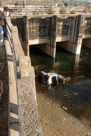 सुबह नहर में गिरी कार को देखने के लिए पुल पर लोगों की भीड़ जुट गई।