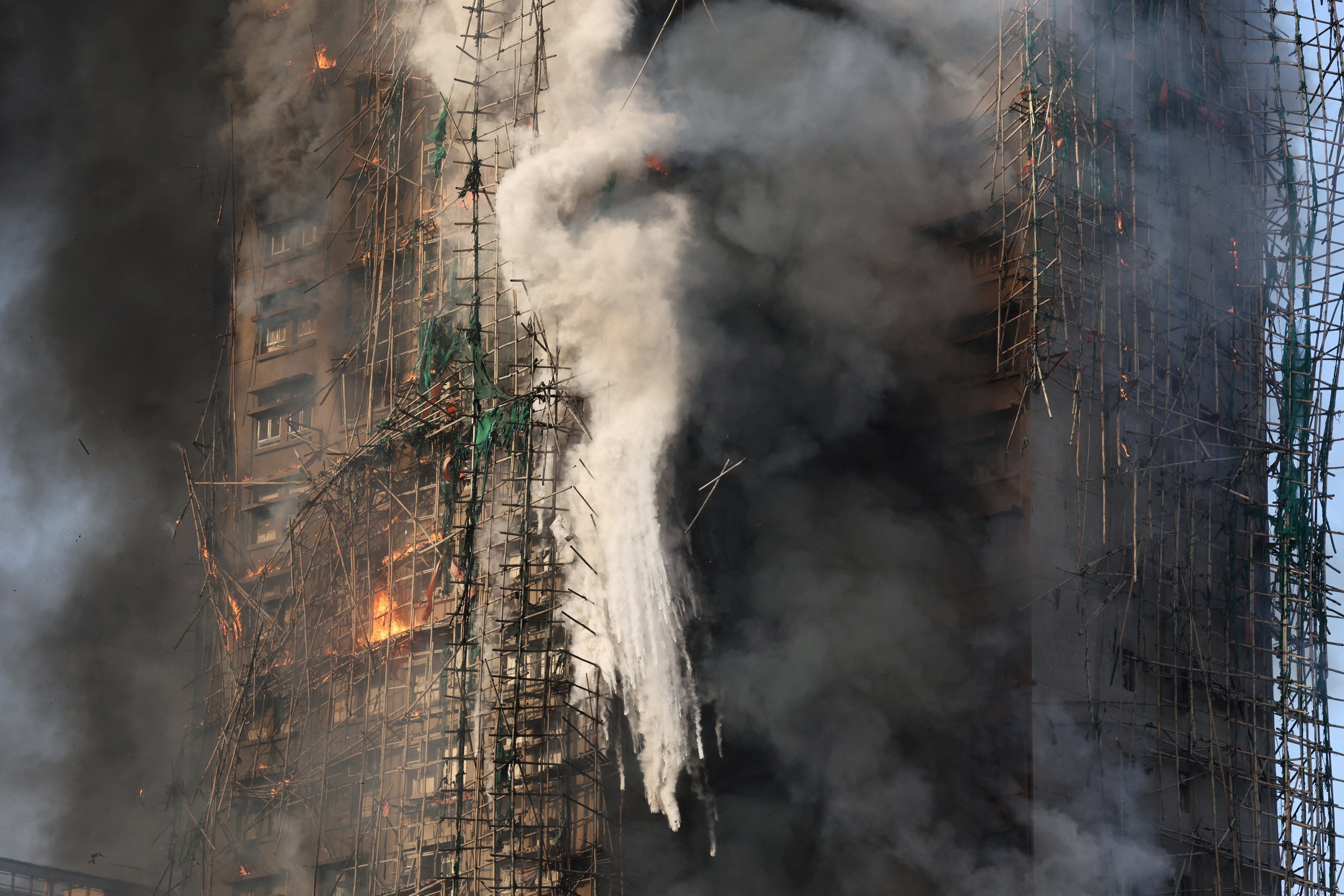 In the footage obtained from the incident site, it is seen that the bamboo scaffolding installed outside several flats of the building is engulfed in strong flames.