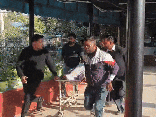 आग में झुलसी लड़की को अस्पताल में भर्ती कराते हुए लोग।