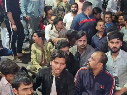 जमीन पर बैठकर दुकानदारों ने प्रदर्शन किया।