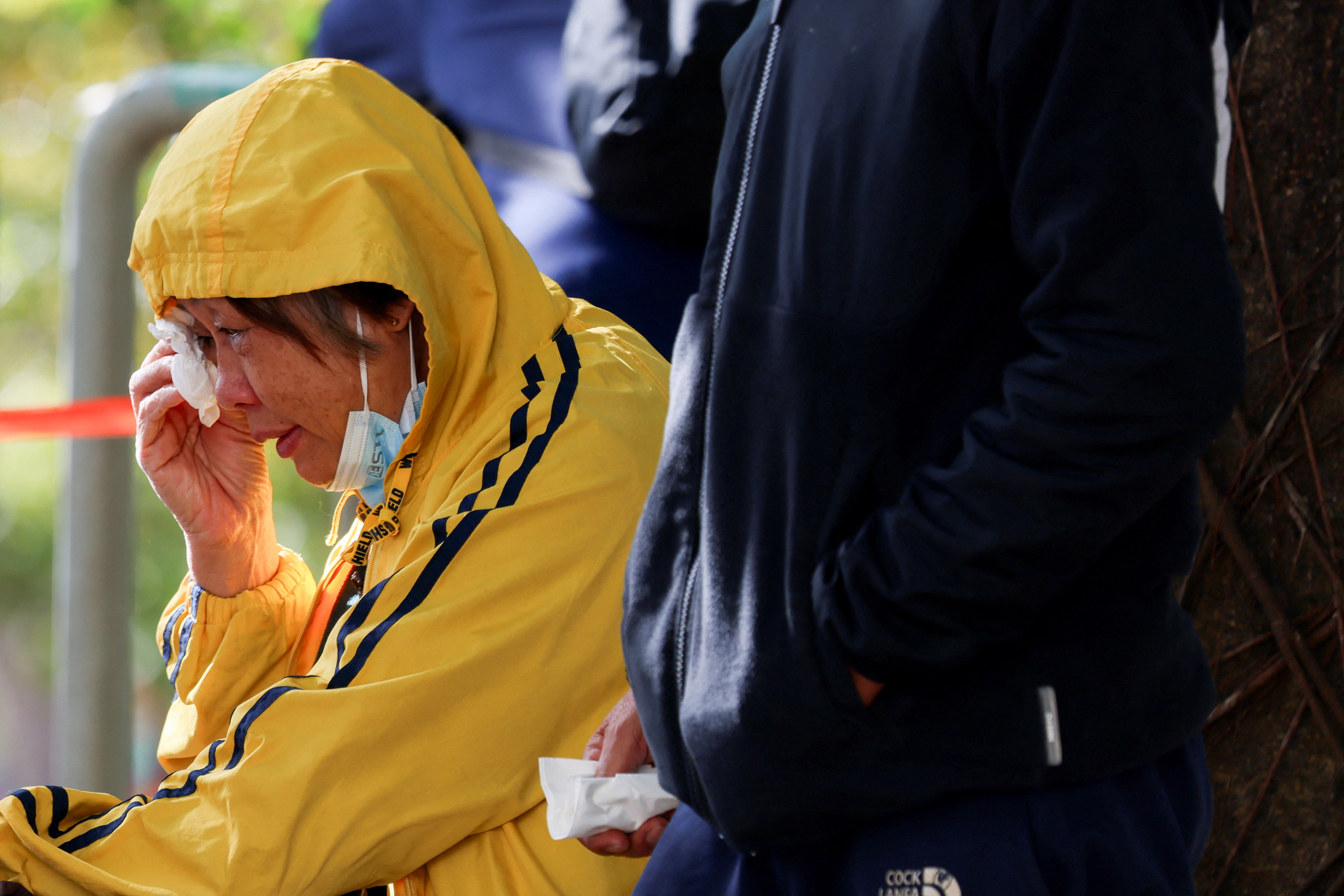 हाउसिंग कॉम्प्लेक्स में आग लगने के बाद कम्युनिटी हॉल के बाहर एक महिला अपना घर जल जाने के बाद रोते हुए।