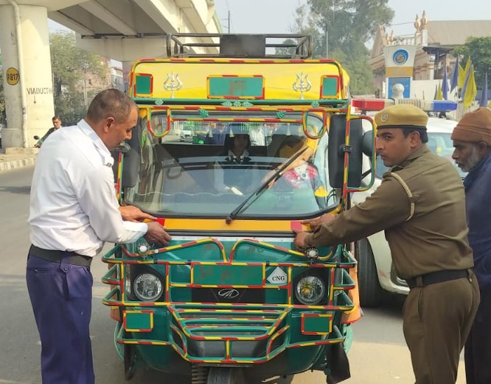 दिल्ली रोड पर थ्रीव्हीलर को रिफ्लेक्टर टेप लगाते पुलिसकर्मी।
