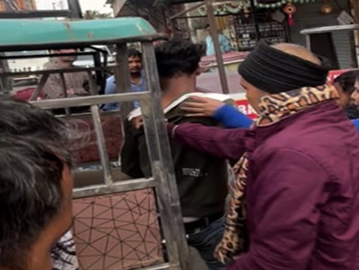 युवक को पकड़कर ई-रिक्शा में बैठाते हुए।