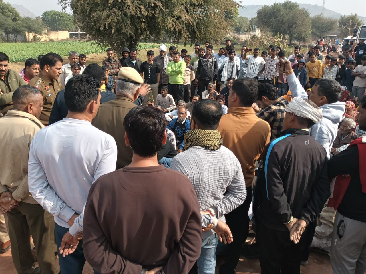 धरने के बीच ग्रामीणों का समझाने पहुंचे पुलिस अधिकारी।