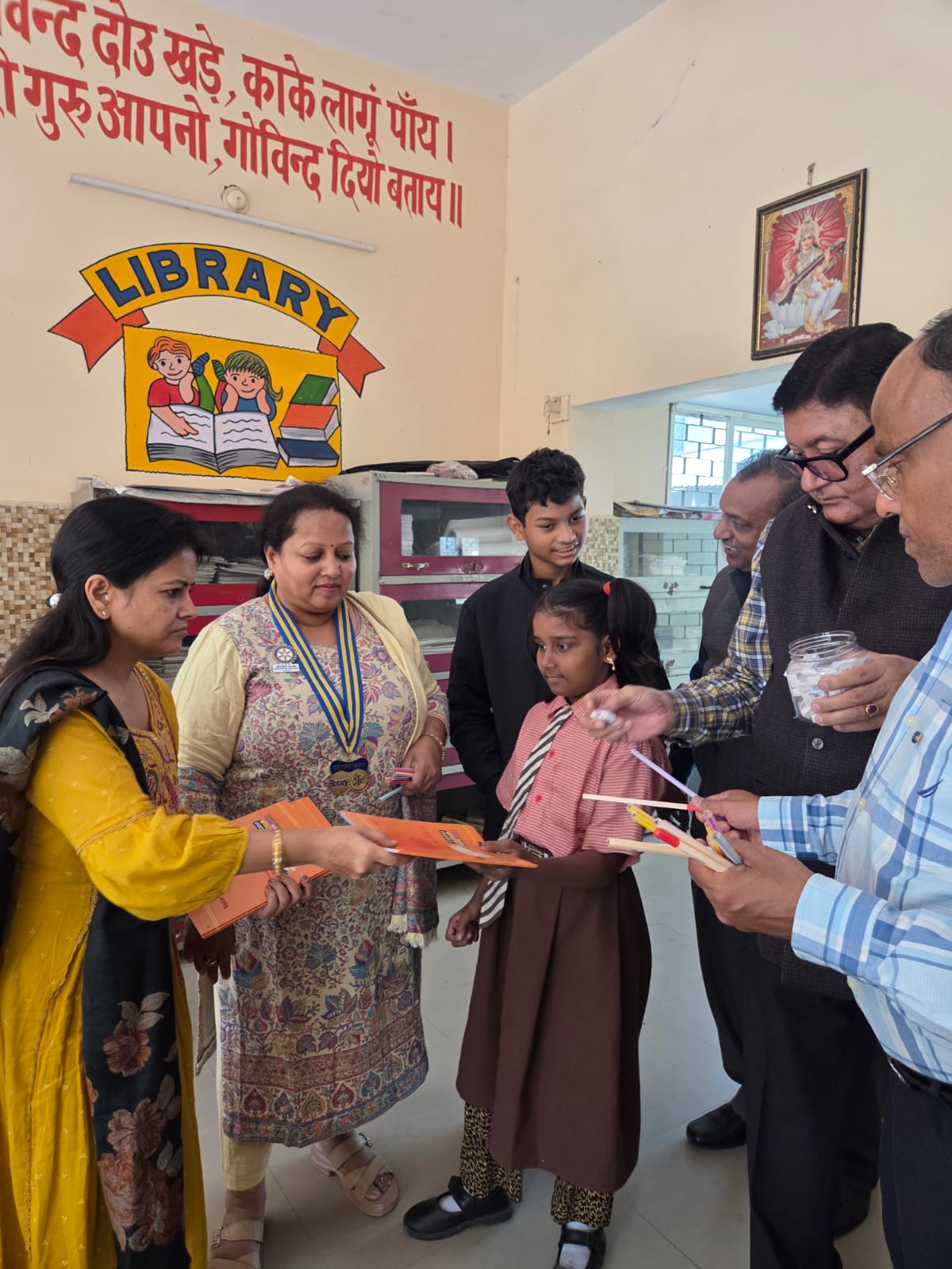 विद्यार्थियों को स्टेशनरी का सामान देते क्लब के सदस्य