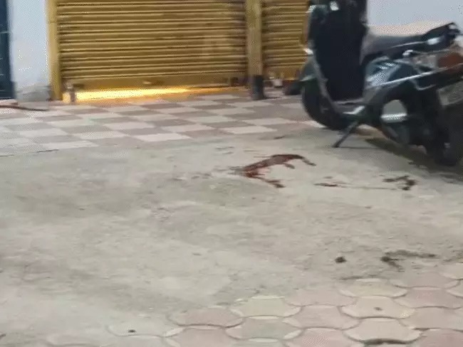 दुकान के बाहर बिखरा खून। बदमाशों की गोली से दुकानदार घायल हुआ था।