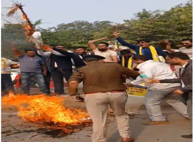 प्रदर्शन के दौरान पुतले को जलाते हुए आंदोलनकारी।