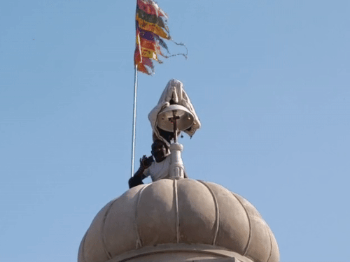 श्रीगंगानगर में अनूपगढ़ के गांव 15ए में मंदिर के शिखर पर बैठा राजमिस्त्री पूर्णराम।