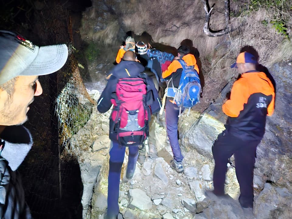 त्रियुंड ट्रैक पर गिरे कर्नाटक के ट्रैकर का शव पहाड़ी से नीचे लाते हुए वन मित्र और एसडीआरएफ जवान।