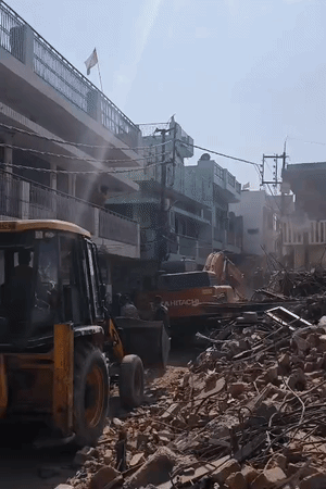 एक्शन पर रोक लगने के बाद बुलडोजर वापस जाते हुए।