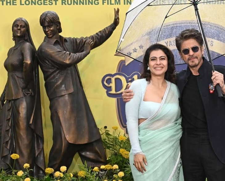 शाहरुख आणि काजोल लंडनच्या लीसेस्टर स्क्वेअरमध्ये त्यांच्या ब्रॉन्झ पुतळ्यासह पोज देताना.