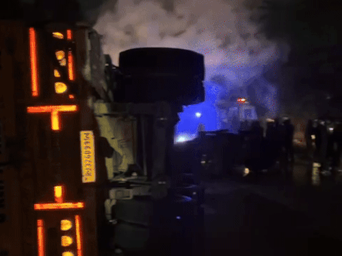 सड़क के बीच पलटा आग लगा ट्राला।