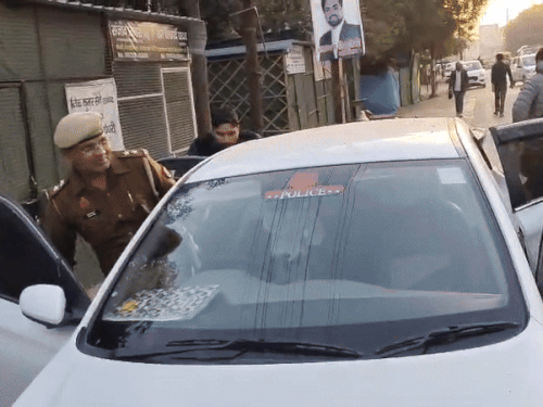 कोर्ट परिसर में महिला सिपाही के पिता विपिन कुमार शर्मा (दाईं तरफ चेहरे पर मफलर बांधे) और भाई (बाईं तरफ कार के दरवाजे से झांकते हुए) उससे मिलने पहुंचे।