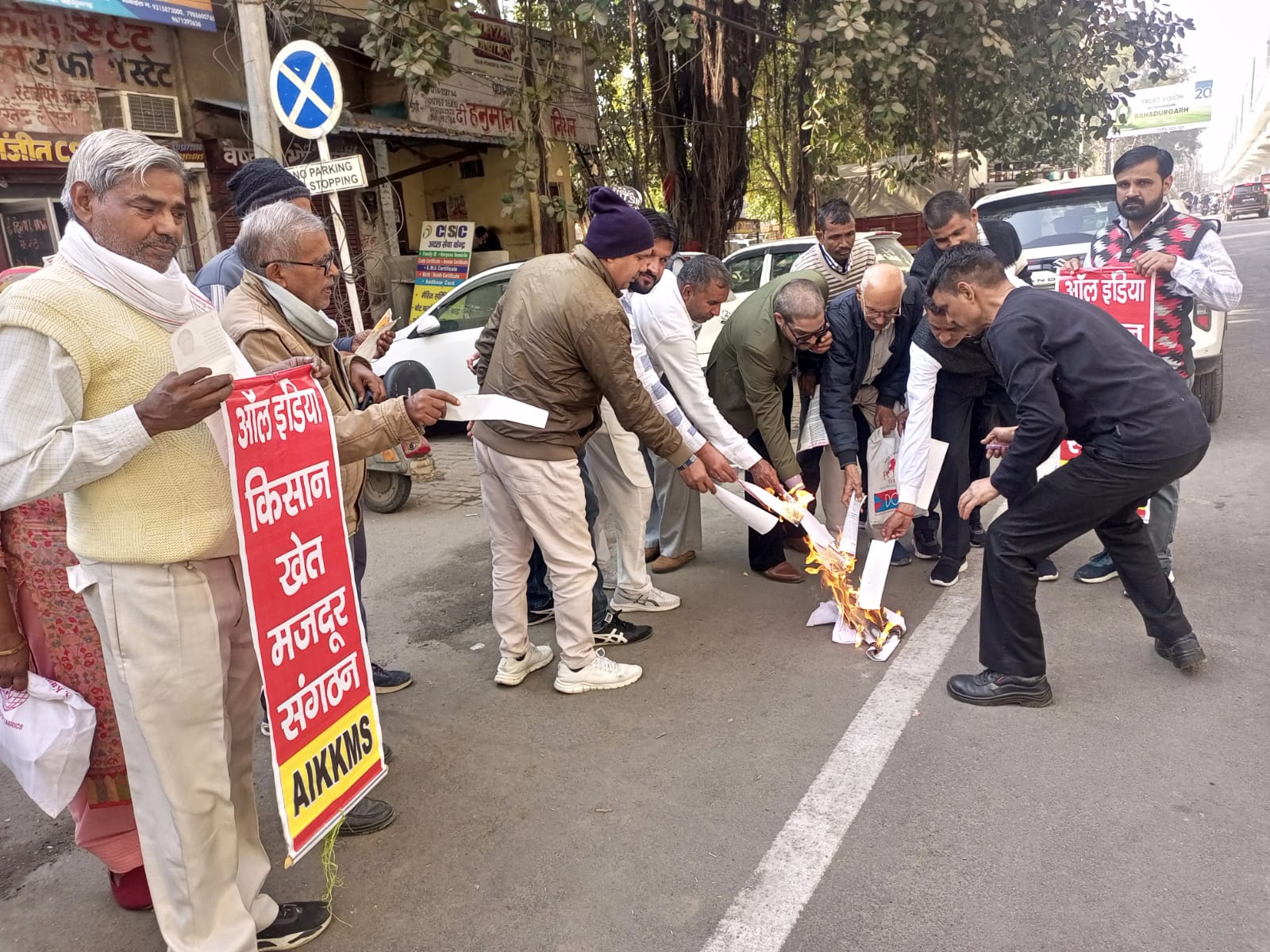 बहादुरगढ़ के रोहतक रोड पर बिलों की प्रतियां जलाते किसान संगठनों के सदस्य।