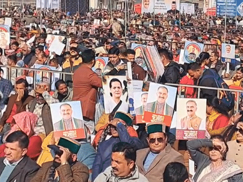 मंडी के जन संकल्प कार्यक्रम में पोस्टर के साथ मौजूद लोग।