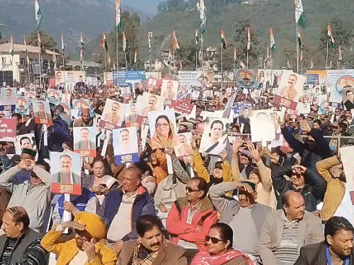 जन संकल्प कार्यक्रम में हाथों में पोस्टर लिए लोग।