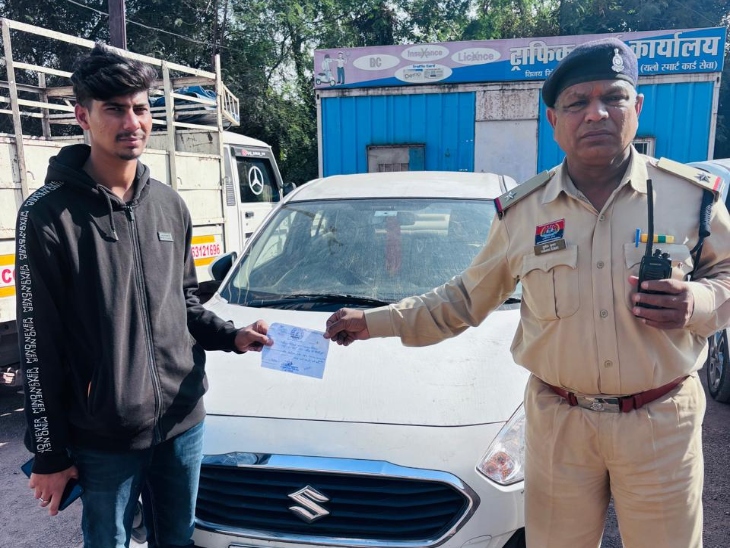 कार में खिड़की पर बैठकर वीडियो बना रहे थे, पुलिस ने काटा चालन।
