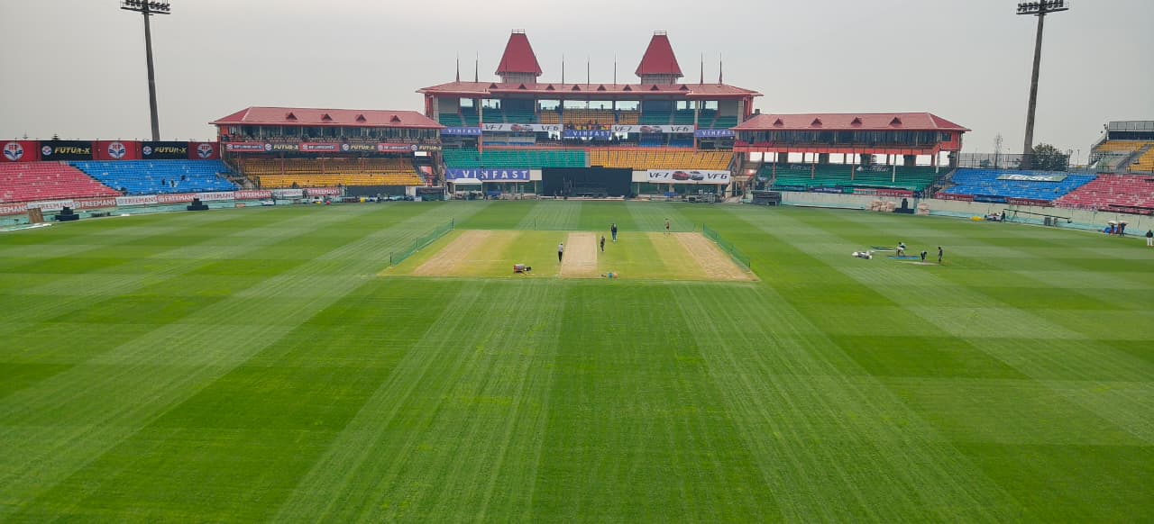 धर्मशाला में कल होने वाले मैच से पहले तैयार क्रिकेट स्टेडियम और आसमान में छाए बादल।