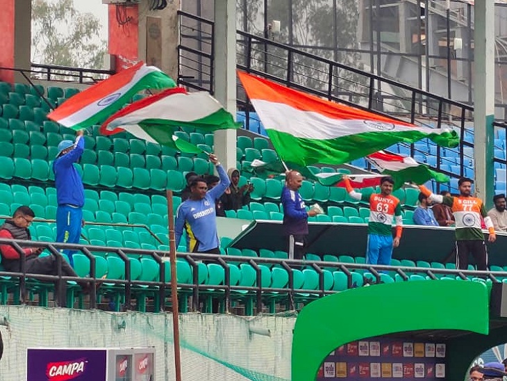 धर्मशाला में कल होने वाले मैच से पहले तिरंगा लहराते हुए भारतीय टीम के प्रशंसक।