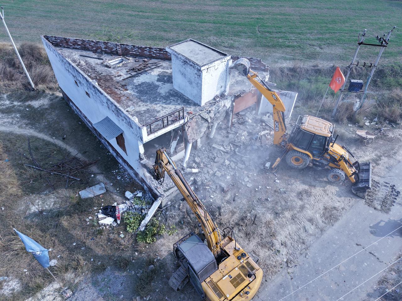 अवैध निर्माण पर कार्रवाई करता बुलडोजर।