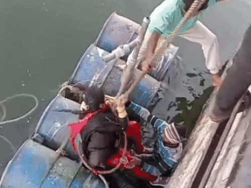 झील से बाहर निकालने पर युवती थककर ड्रम पर बैठ गई।