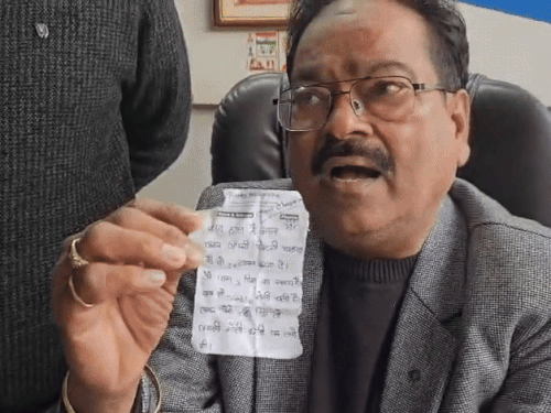 बदमाश द्वारा दी गई पर्ची को दिखाते कपड़ा व्यापारी नरेश जैन।
