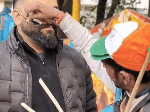 धर्मशाला में मैच देखने पहुंचा युवक फेस पर तिरंगा बनवाता हुआ।