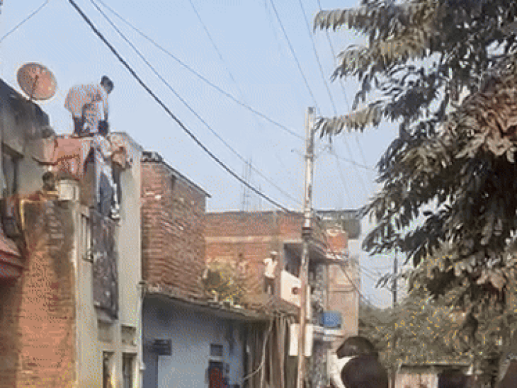 घर की छत से युवक फायरिंग कर रहा है। जबकि महिलाएं पत्थर फेंक रही हैं।