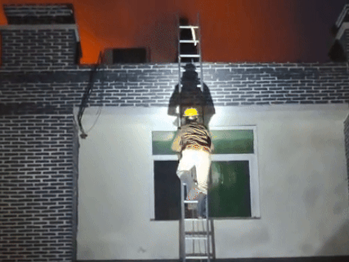 आग बुझाने के लिए फैक्ट्री की छत पर चढ़ते कर्मी।