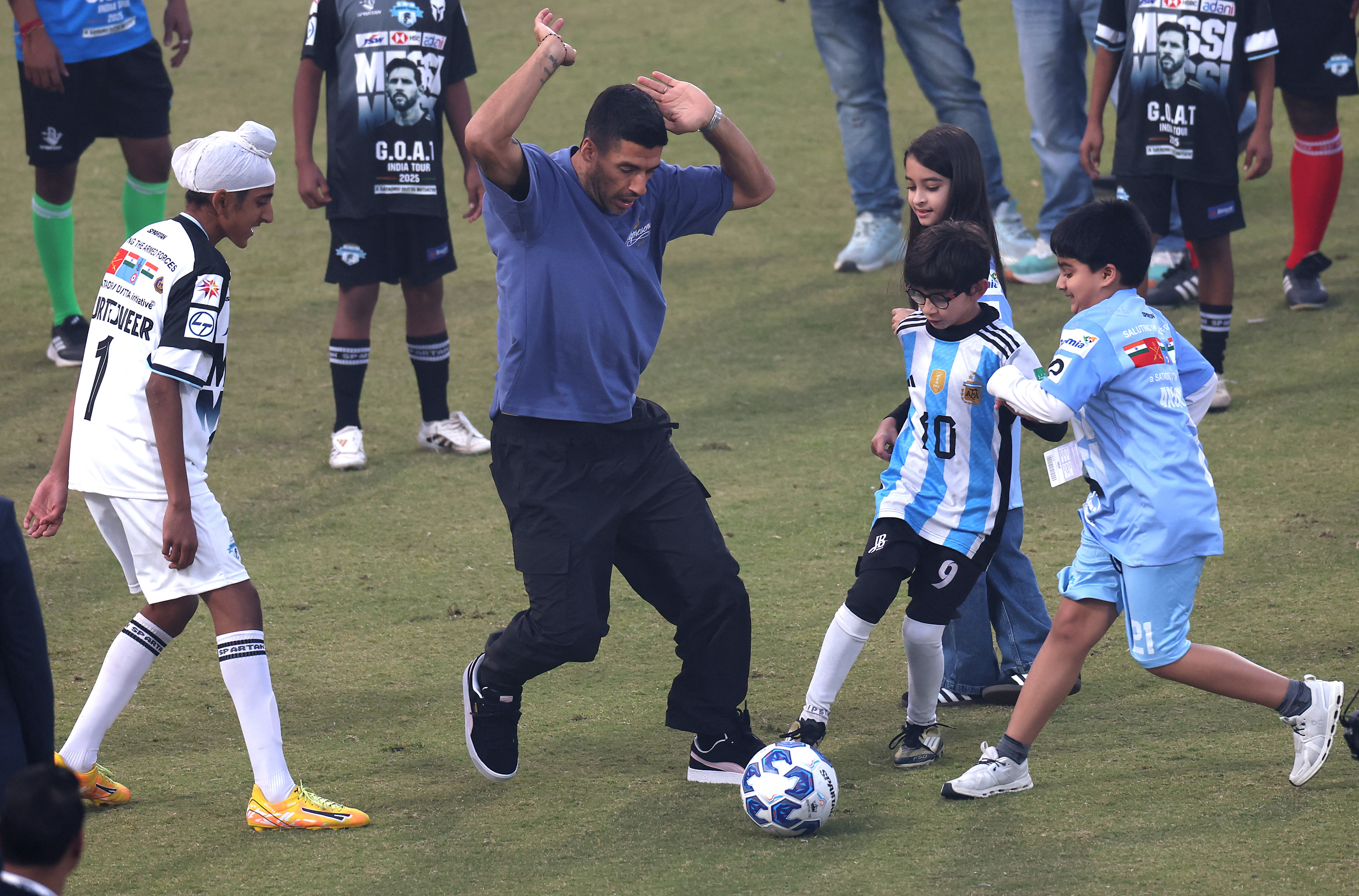 बच्चों के साथ फुटबॉल खेलते उरुग्वे के लुईस सुआरेज।