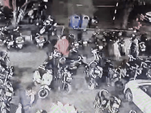 लाल रंग की जैकेट पहने आरोपी चोरी से पहले इधर-उधर देखता हुआ।