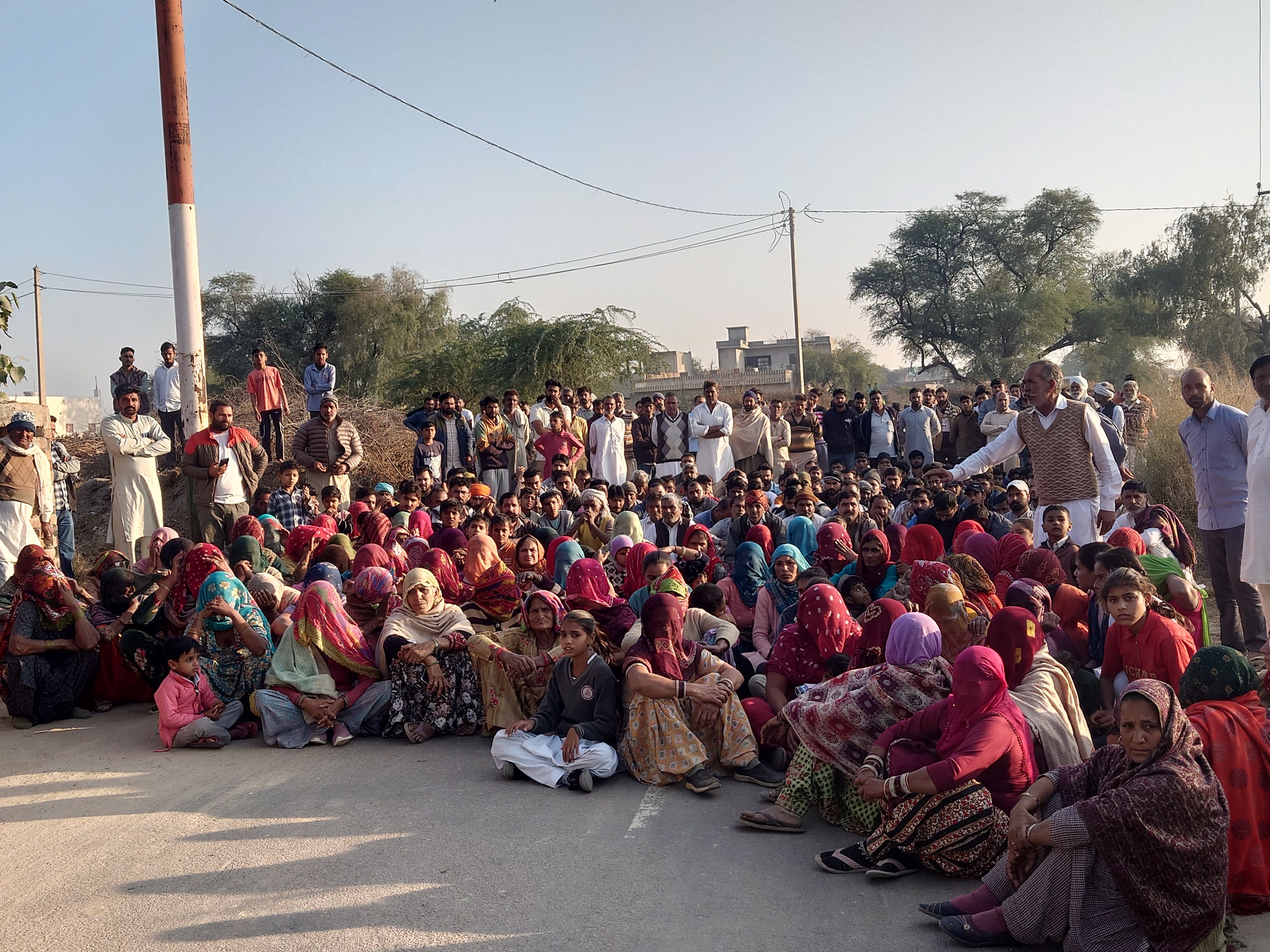 गांव में बच्ची के न्याय की मांग को लेकर धरने पर बैठे परिजन व ग्रामीण।